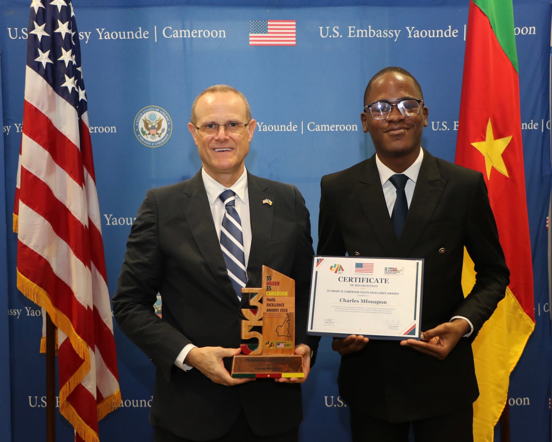 Charles Mfouapon holding the 35 Under 35 award at the U.S. Embassy in Yaoundé